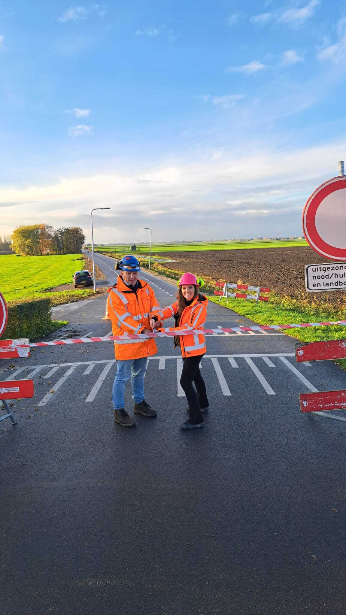 Een foto van het knipmoment. Een lintje wordt op de weg doorgeknipt