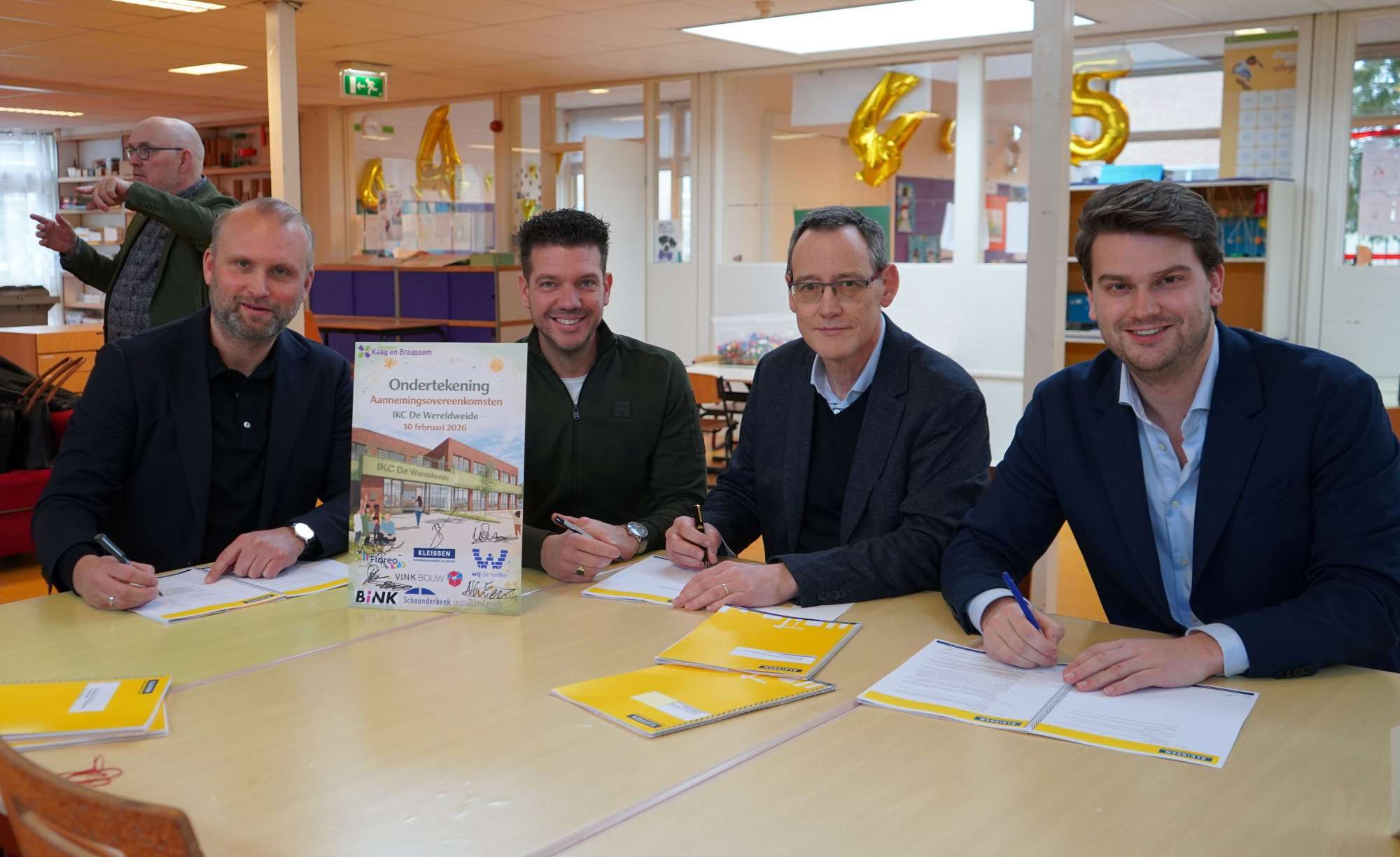Groepsfoto van wethouder Nick van Egmond en partners tijdens het ondertekenen van de aannemingsovereenkomst IKC De Wereldweide