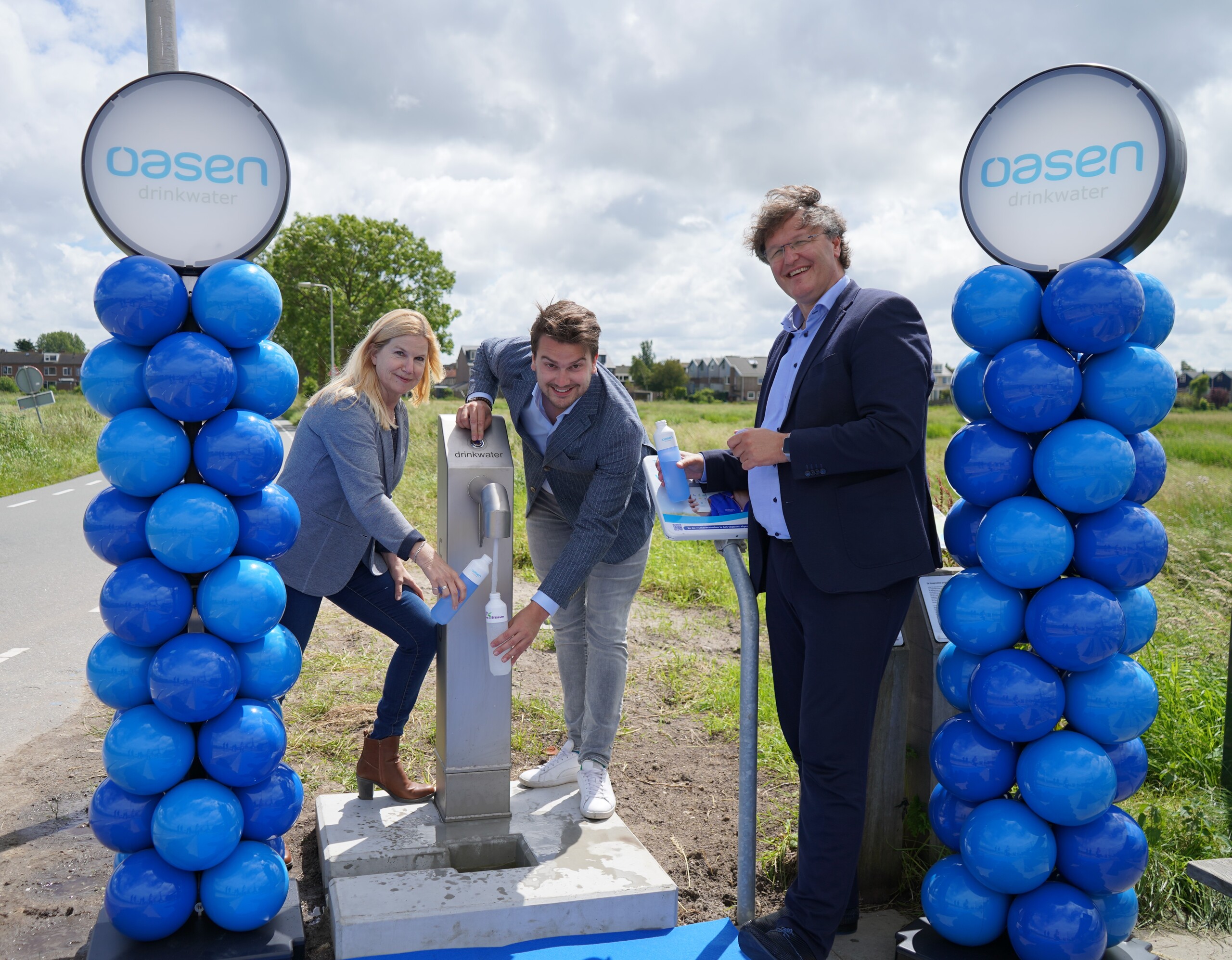 Openingsmoment van de nieuwe watertappunt in Hoogmade. Op de foto staat Kitty Hoogenboom, wethouder Nick van ERgmond en Arjan Driesprong.