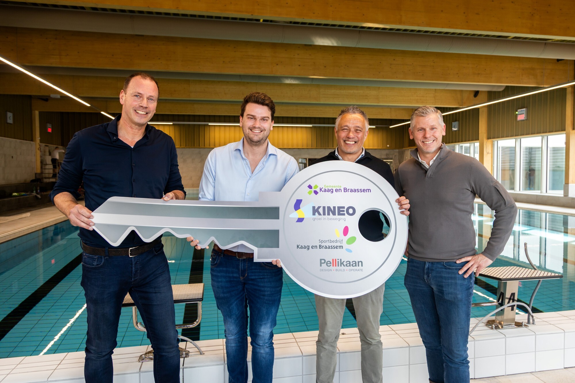 Overhandiging van een symbolische sleutel met de bestuurders bij het zwembad